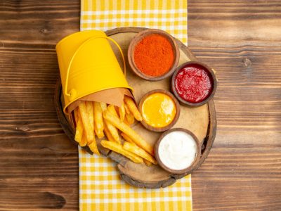 top-view-french-fries-with-seasonings-wooden-table